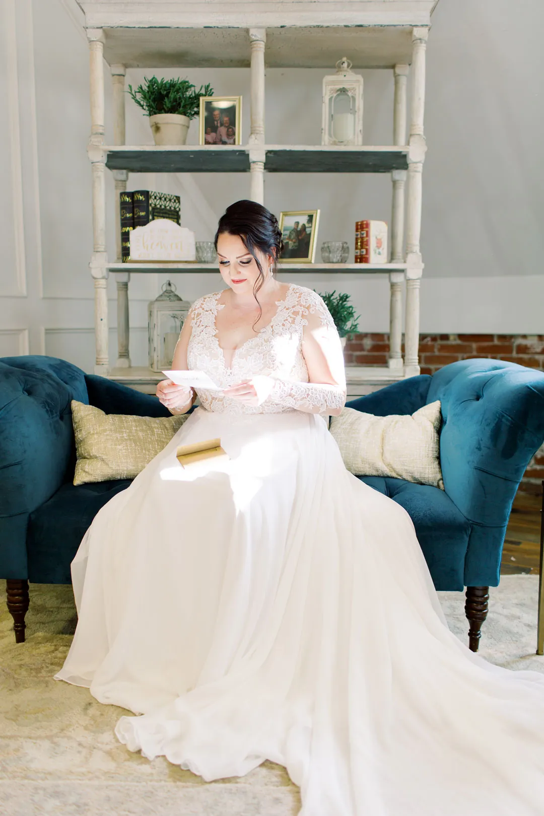 Bride seated on a blue sofa in a bright lounge