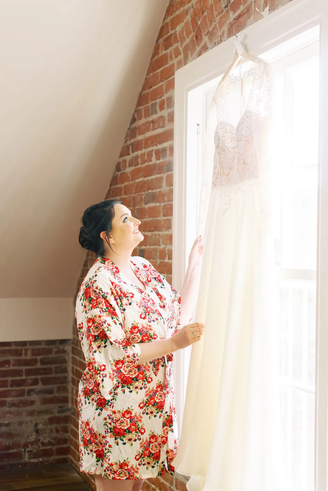 Woman in a floral robe looking toward a tall window