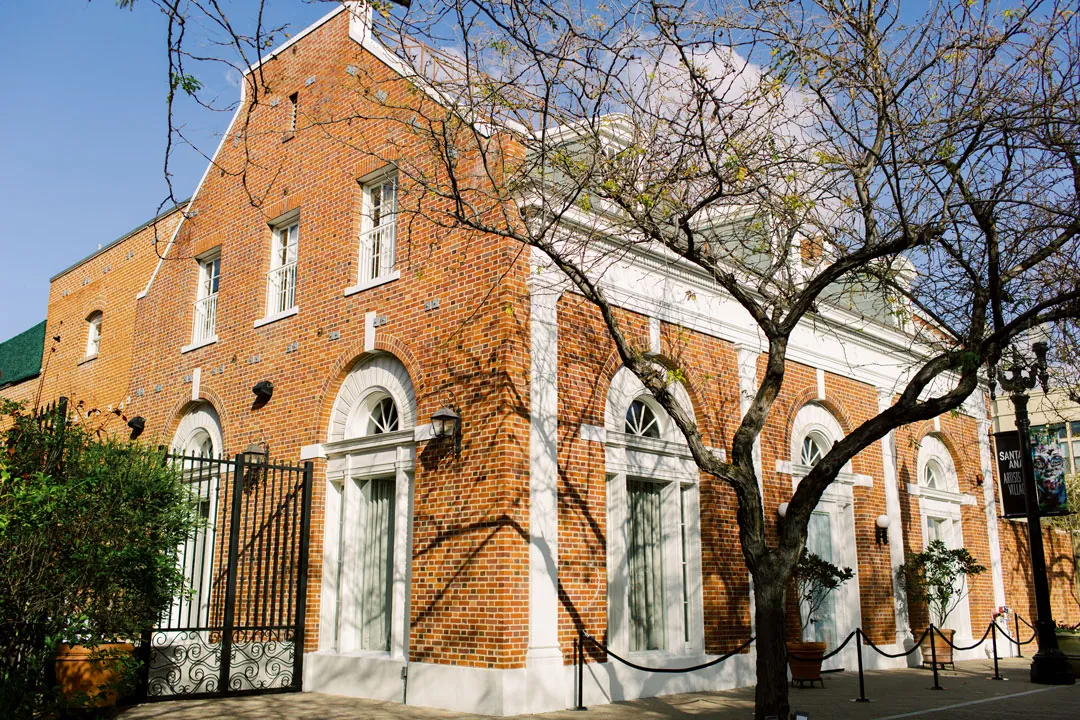 Brick corner building with arched windows beneath a blue sky