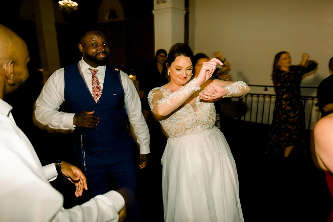 Bride and groom dancing among wedding guests