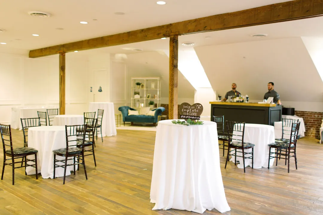 Cocktail tables arranged in a lounge beneath exposed beams