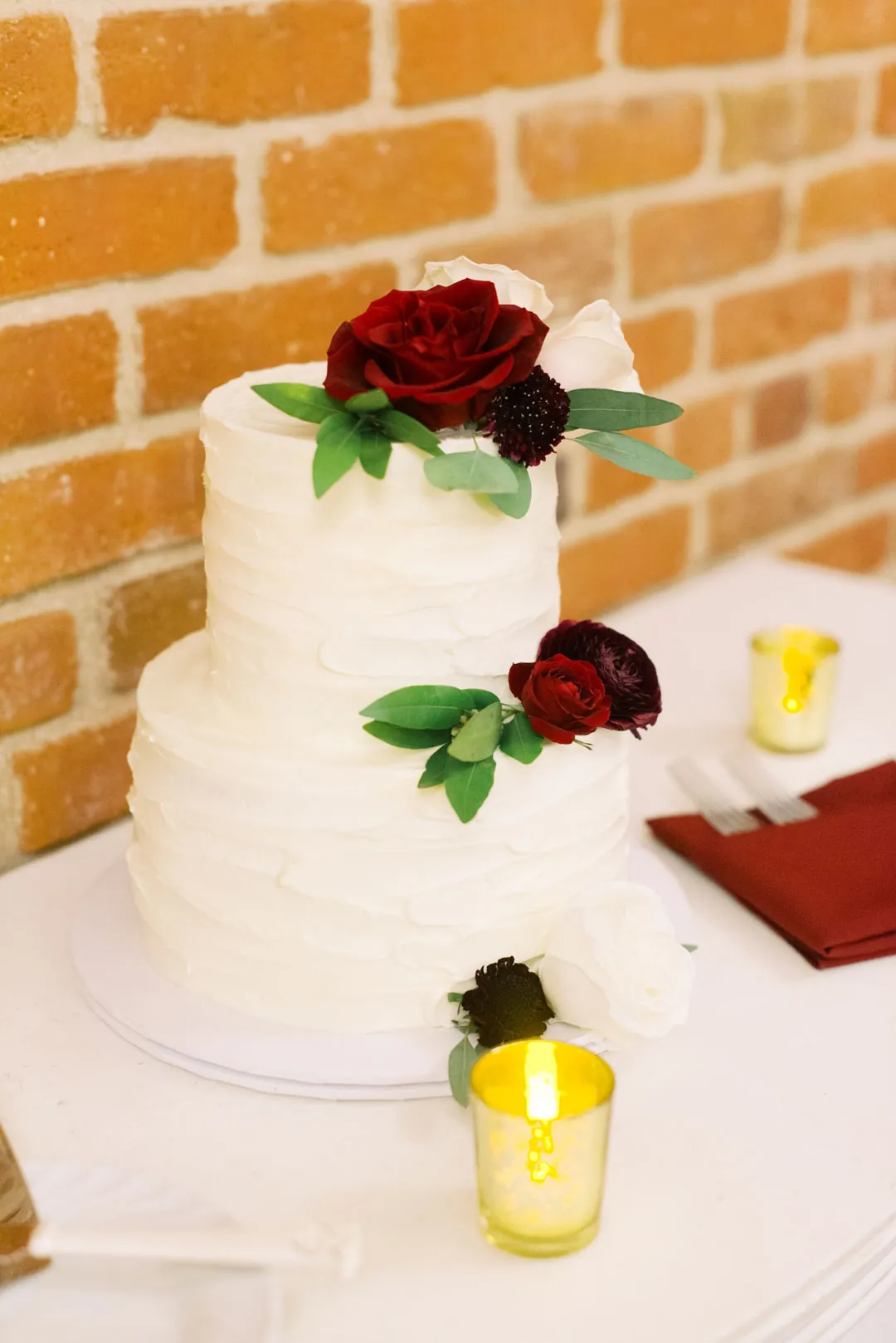 White wedding cake decorated with red flowers