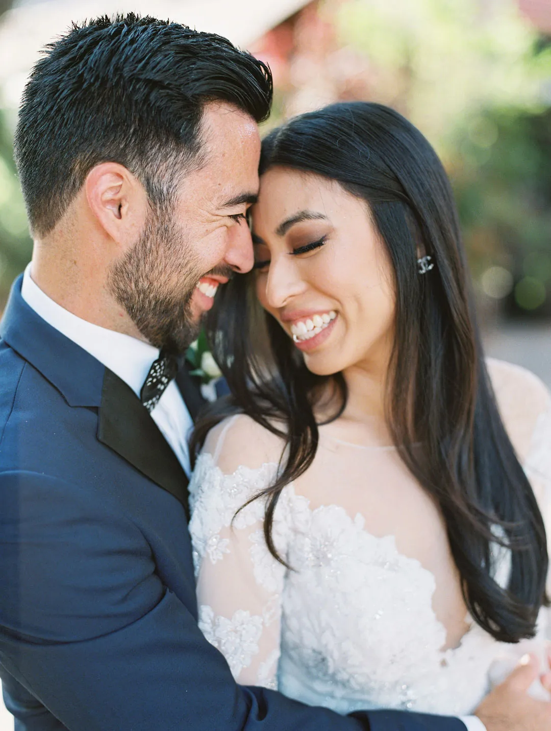 Couple smiling with their foreheads together outdoors