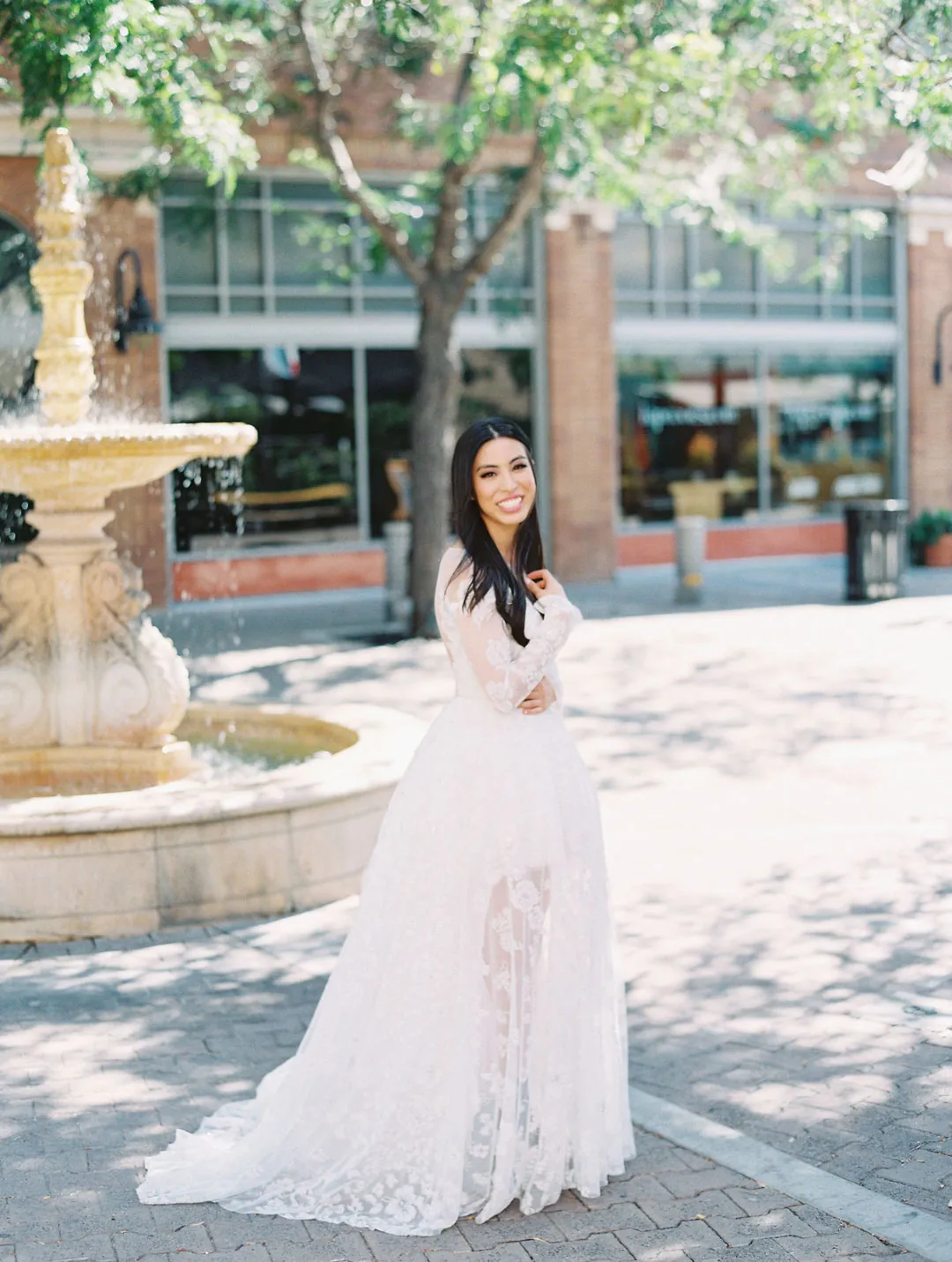 Bride posing beside an outdoor fountain