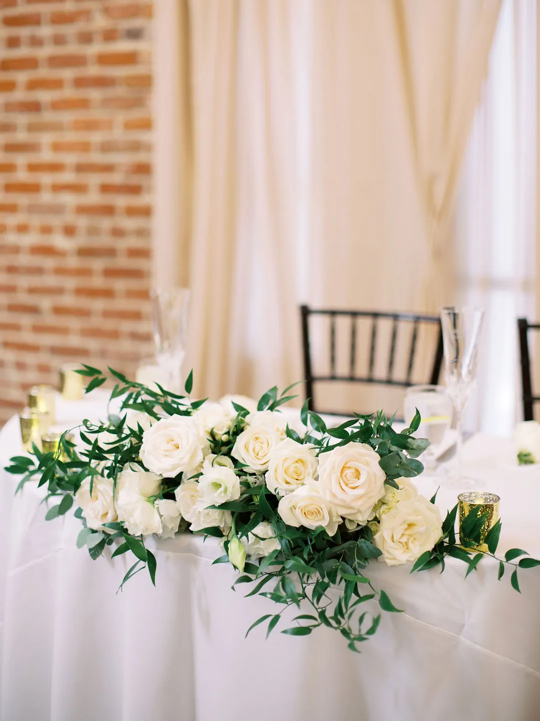 White and green flowers on a round sweetheart table