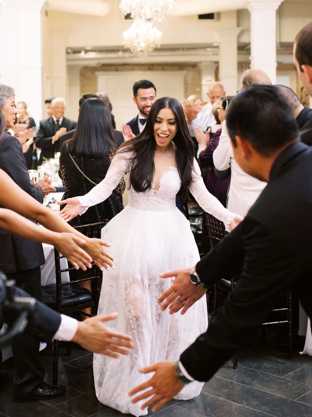 Bride greeting guests as she enters the reception