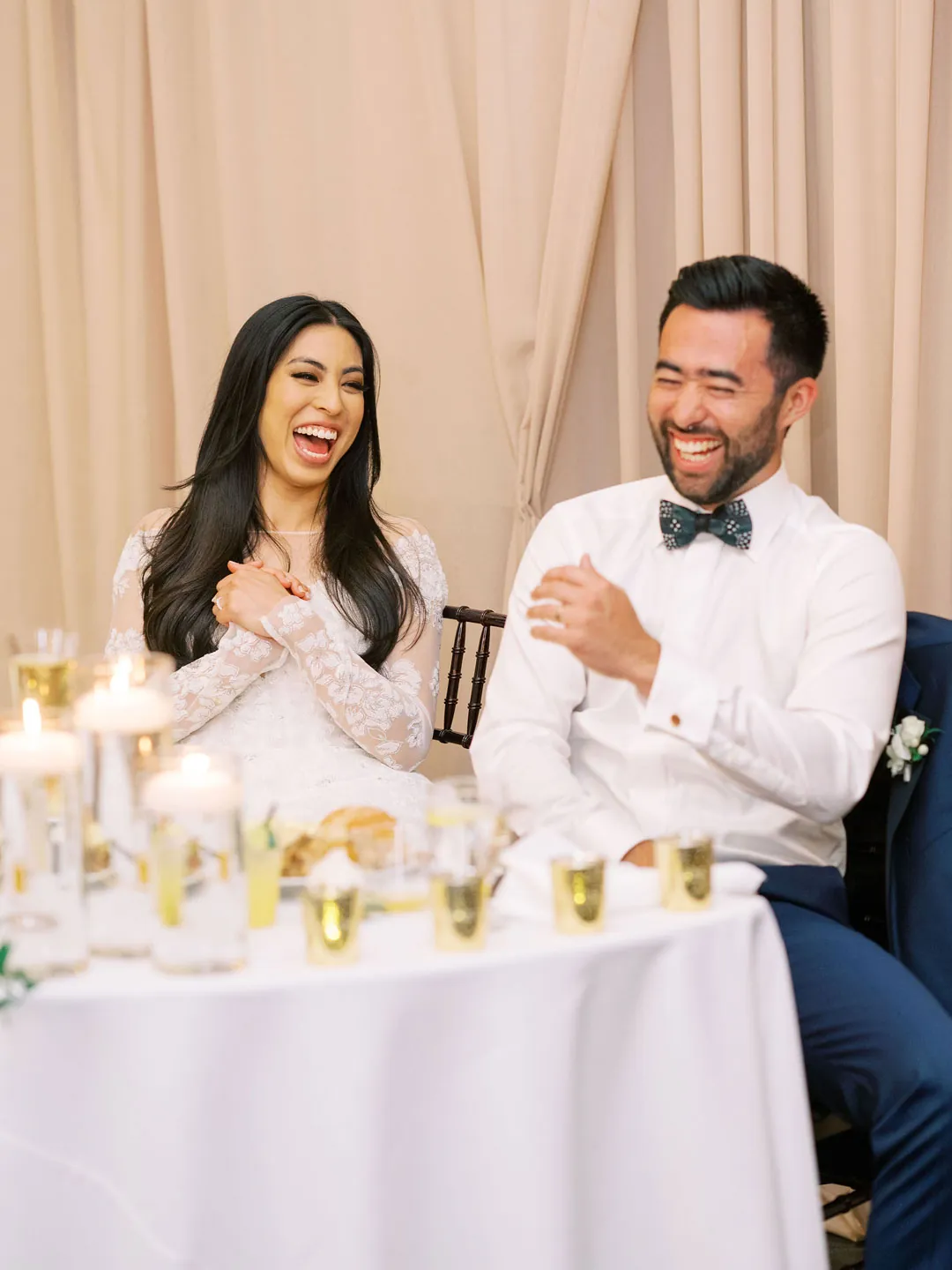 Couple laughing together at their sweetheart table