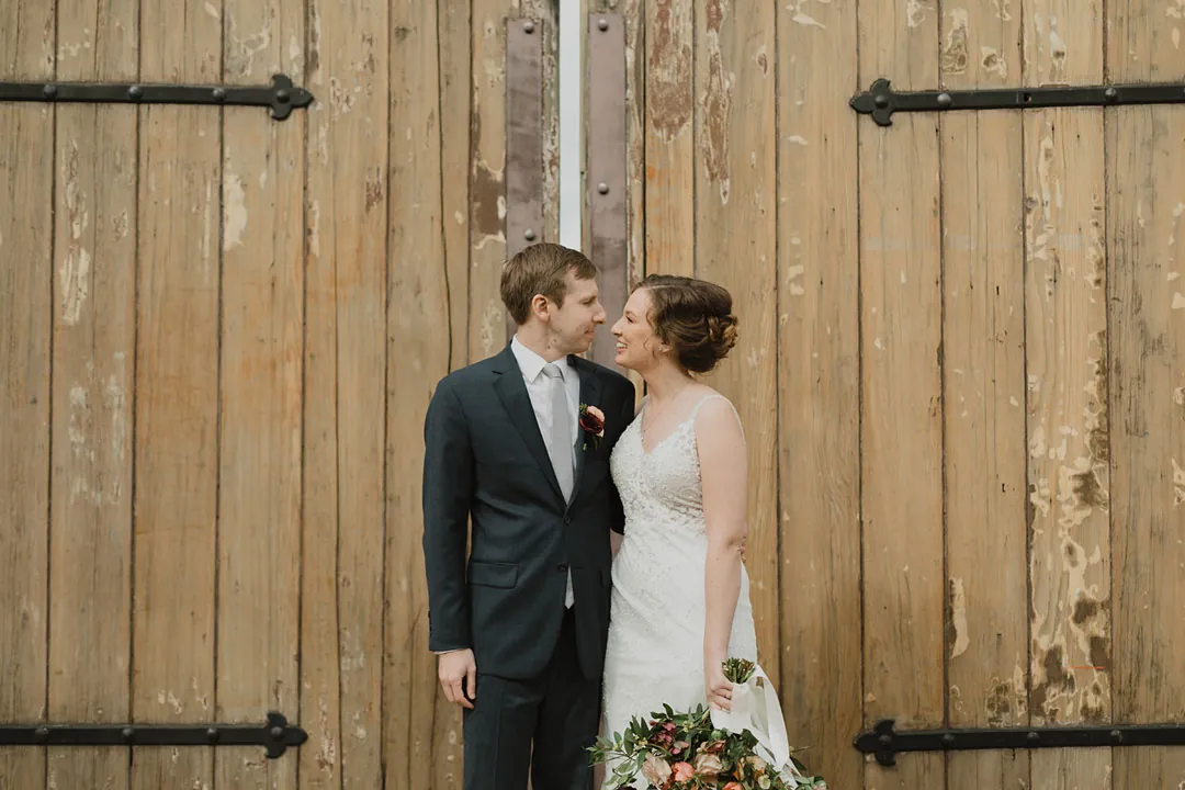 Couple kissing in front of a wooden door