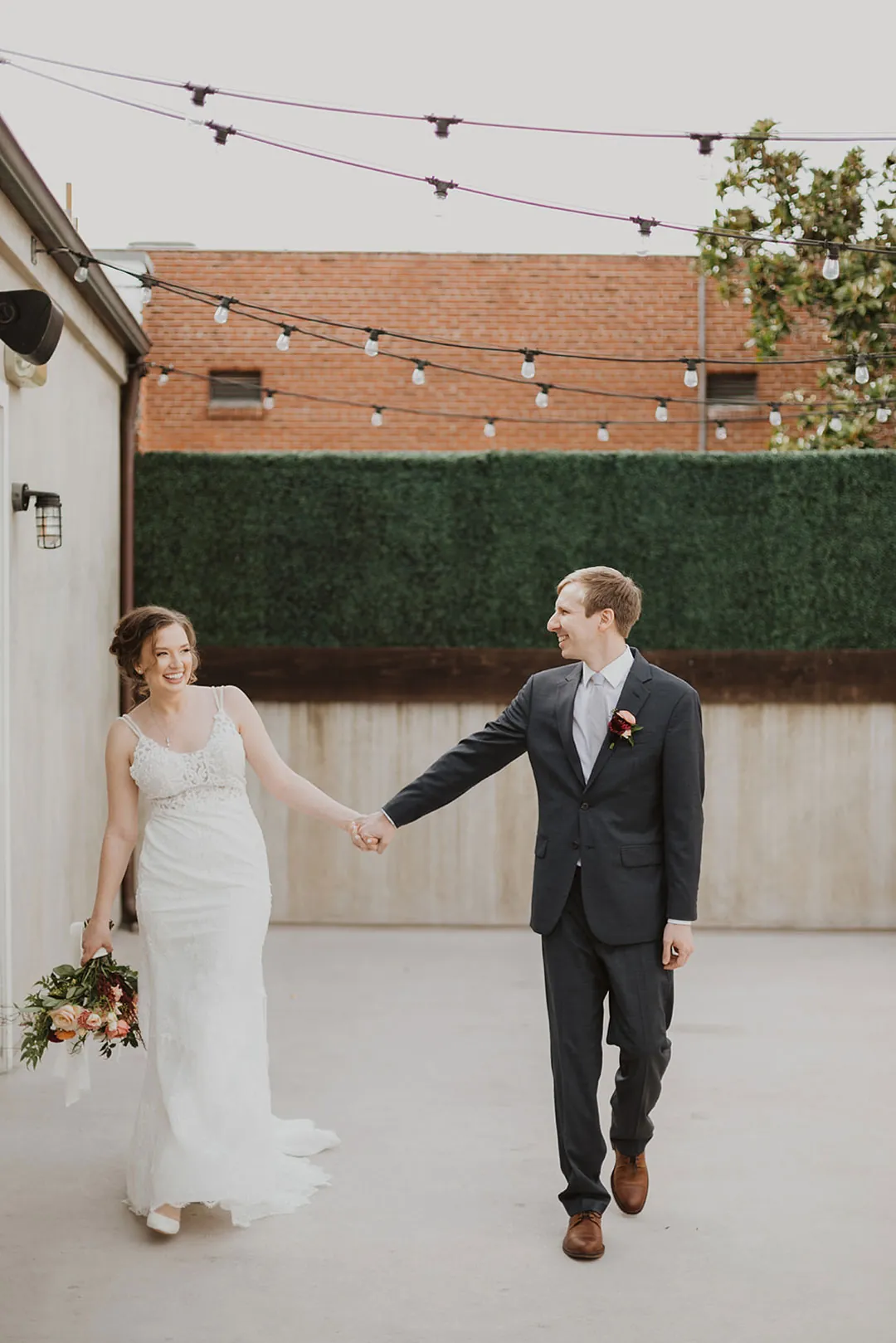 Couple raising their joined hands on an outdoor terrace