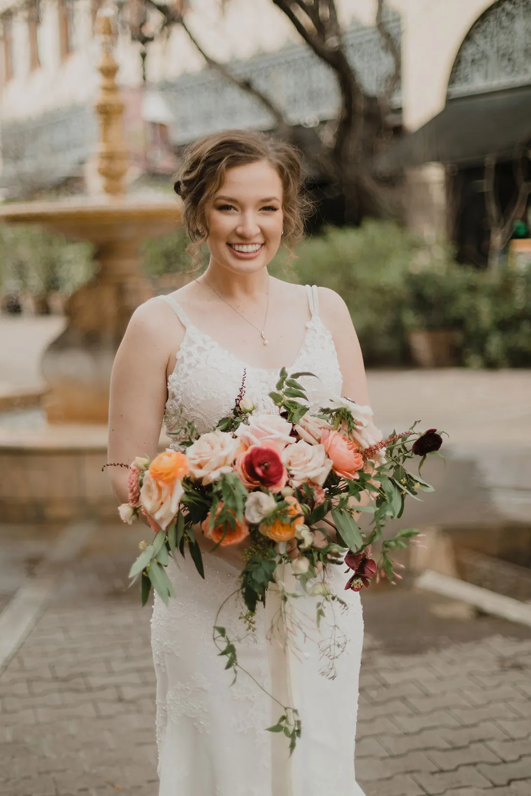 Bride posing with a bouquet in an outdoor plaza
