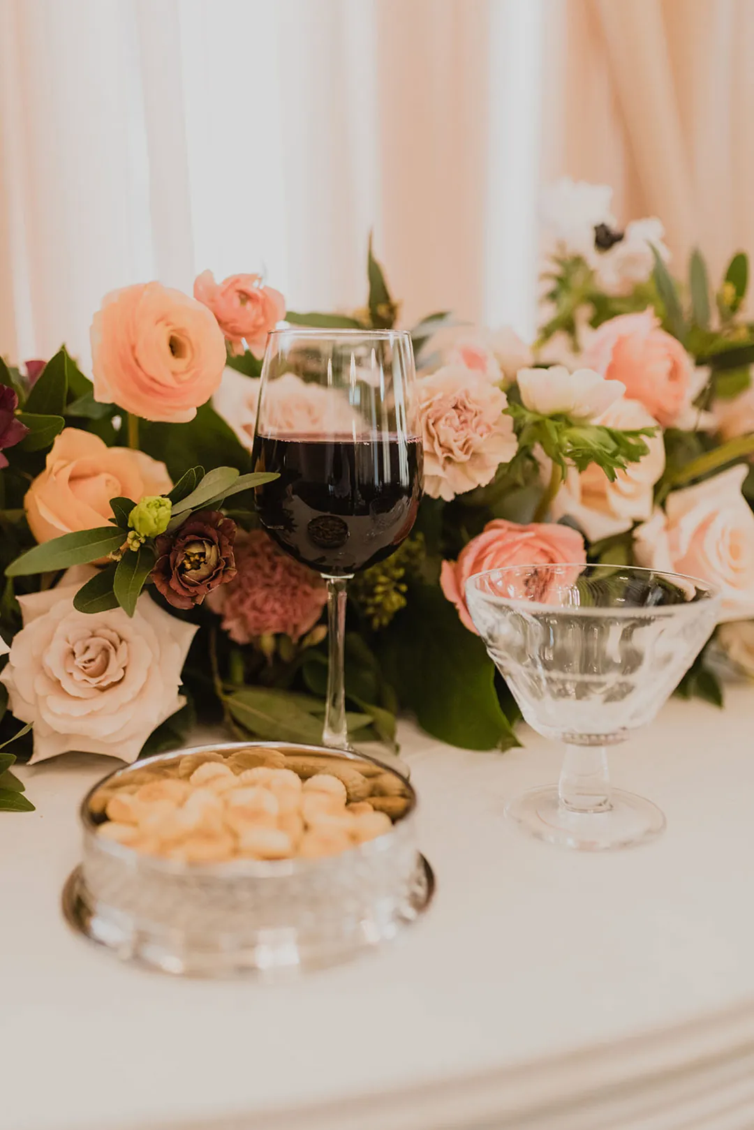 Gold edged dinner plate beside a floral centerpiece