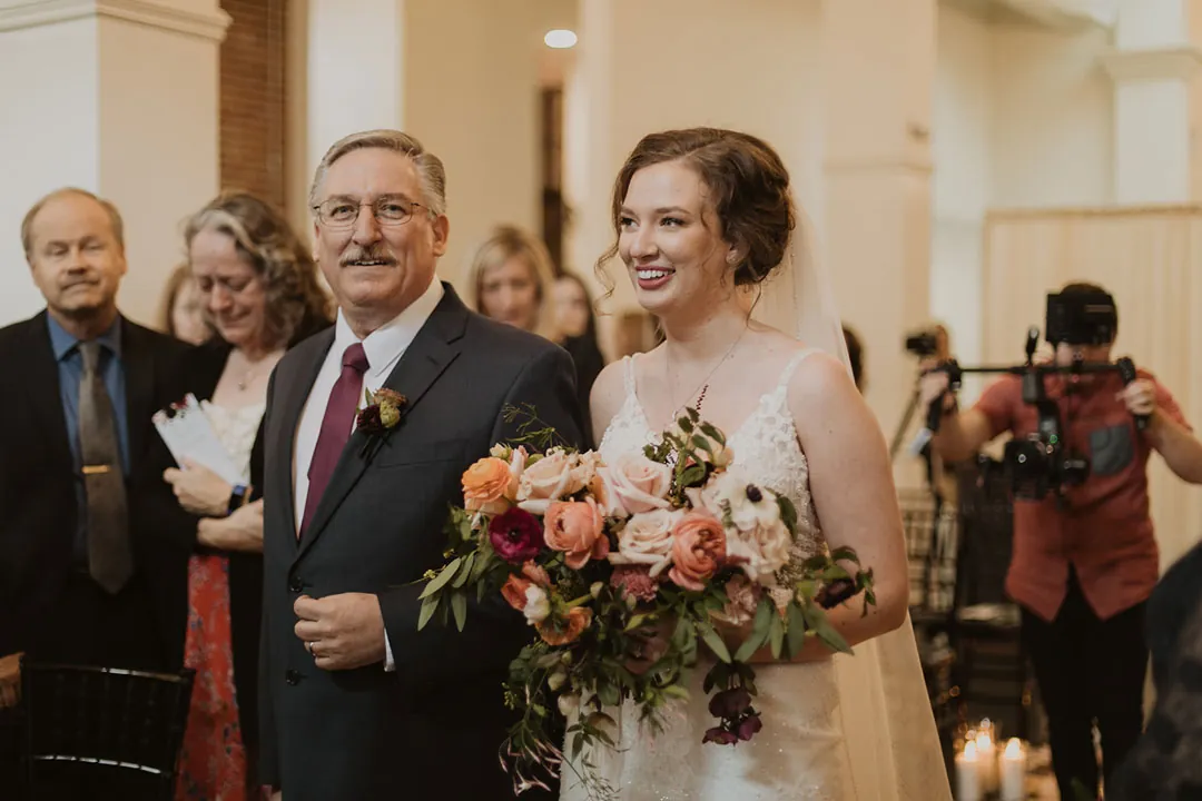 Bride walking down the aisle with an older guest