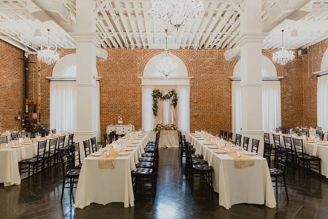 Long reception tables beneath a chandelier