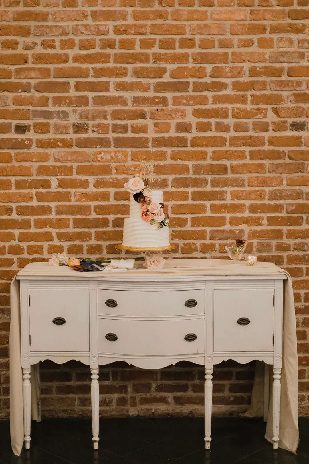 Small tiered wedding cake on a white dresser
