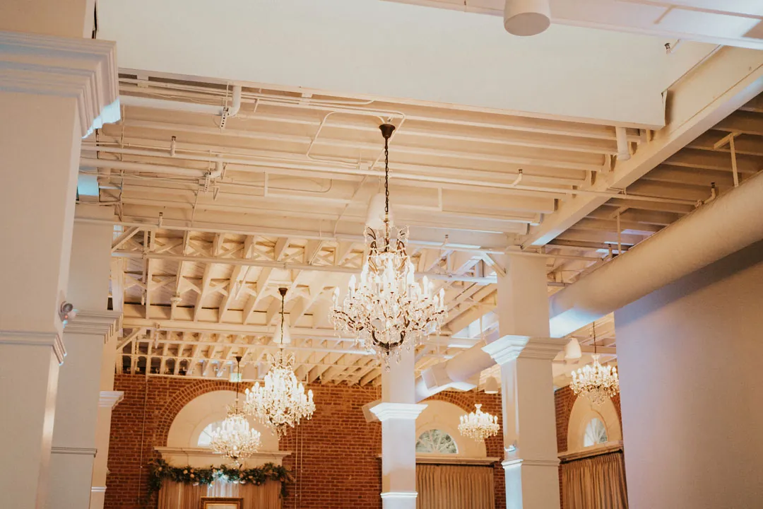 Crystal chandeliers beneath the ballroom's exposed white beams