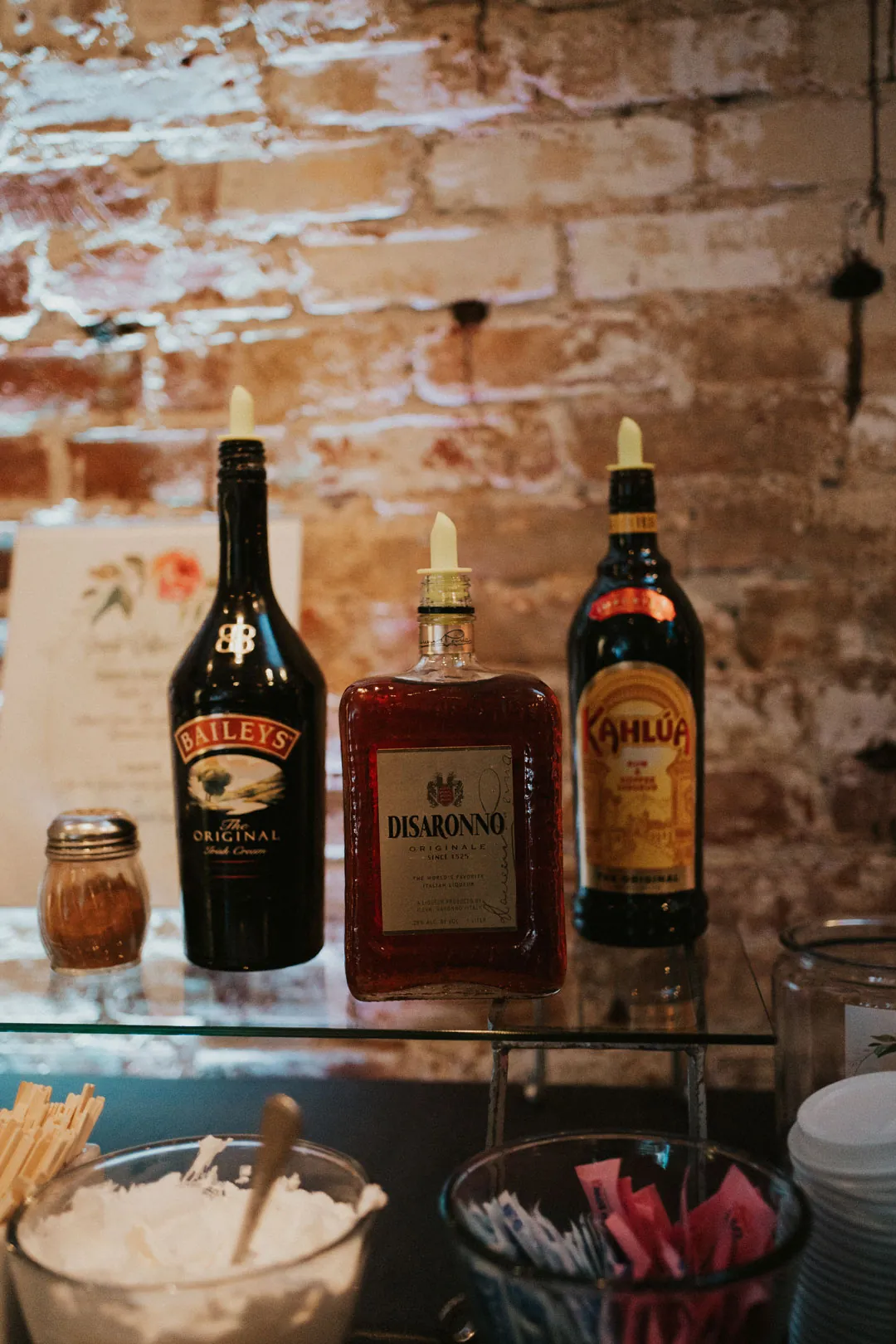 Bottles and cocktail ingredients against exposed brick