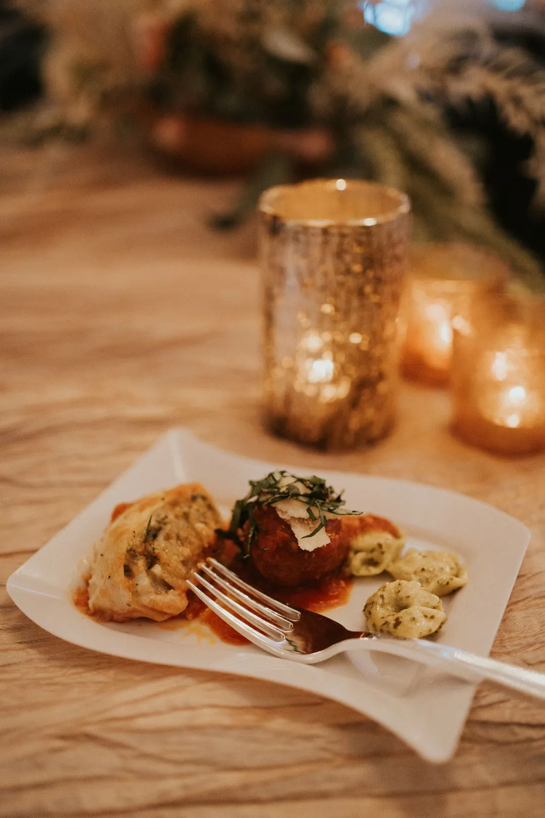 Plated food beside candlelit table decorations