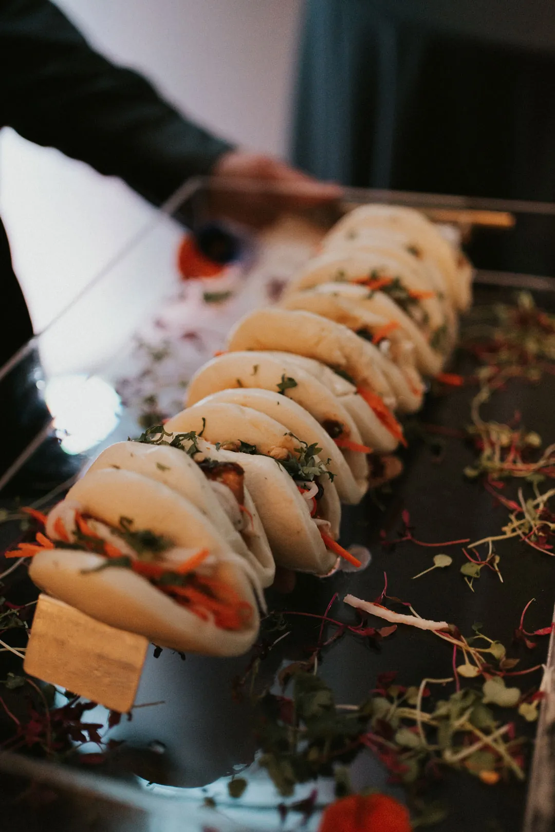 Staff holding a platter of filled tacos