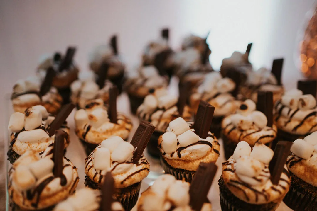 Chocolate-drizzled cupcakes arranged on a tray