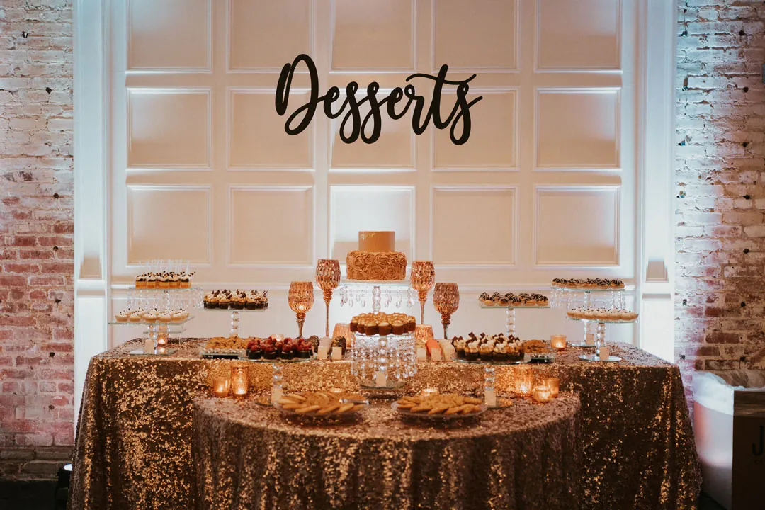 Dessert table beneath a Desserts sign