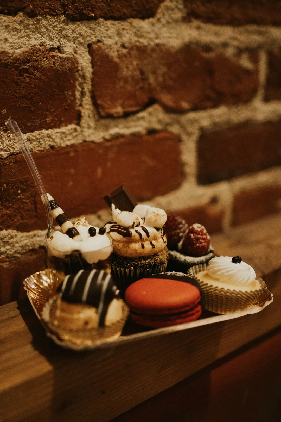 Small desserts displayed against a brick wall