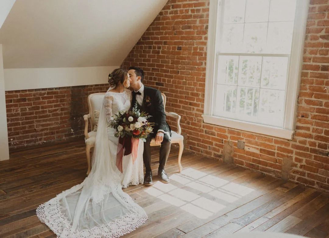 Bride sitting by a window with a bouquet