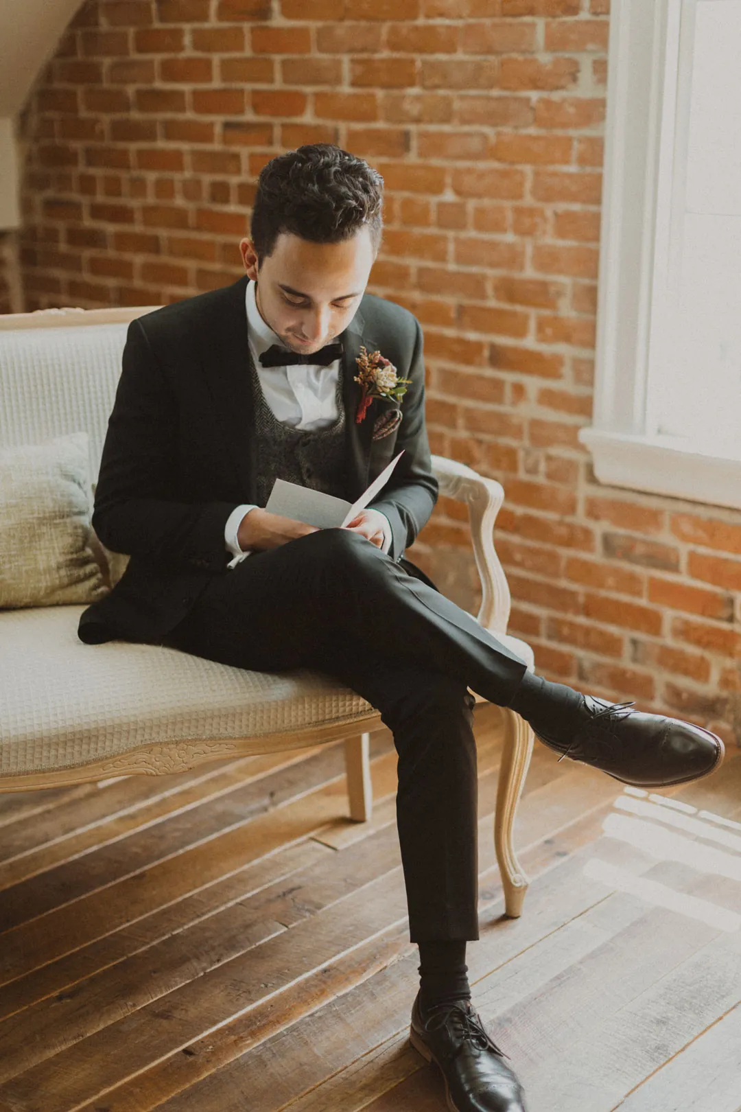 Groom seated while adjusting his shoe