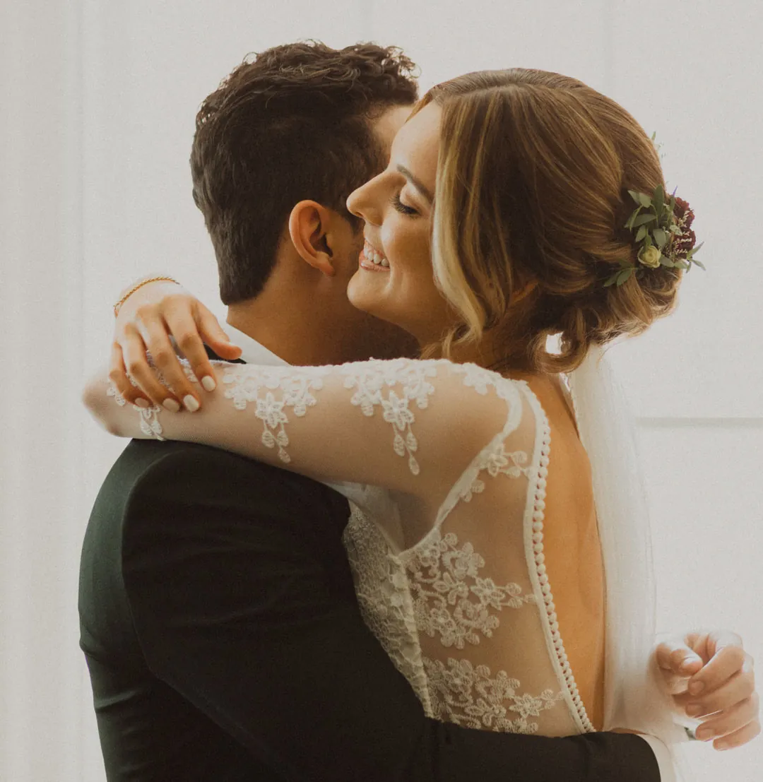 Couple kissing beside an exposed brick wall