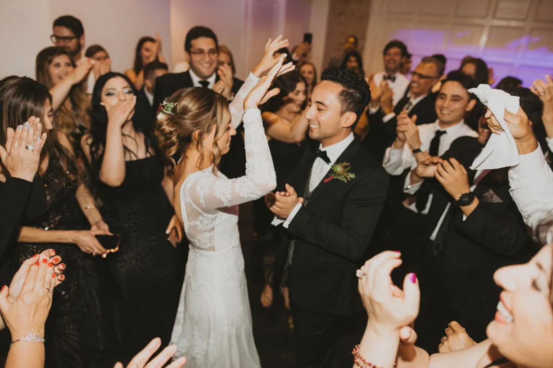 Couple kissing while guests cheer around them