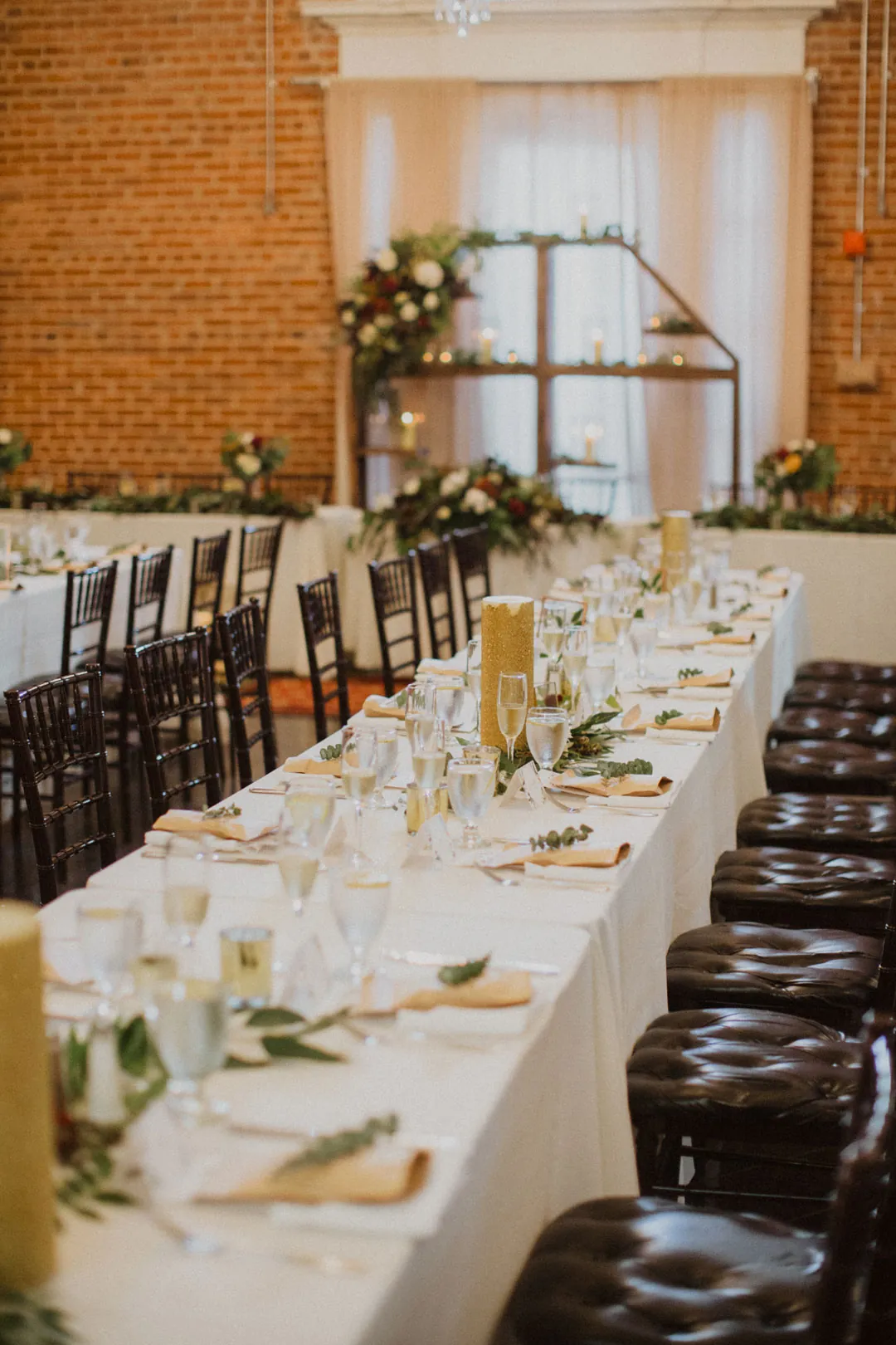 Long dining table set beside a brick wall