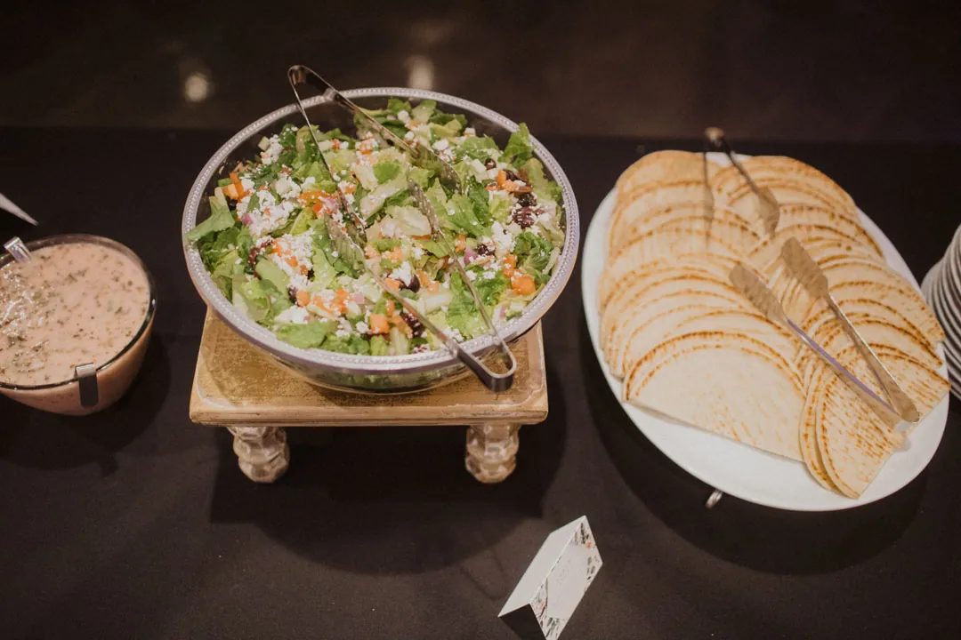 Salad and sliced bread displayed together on a buffet