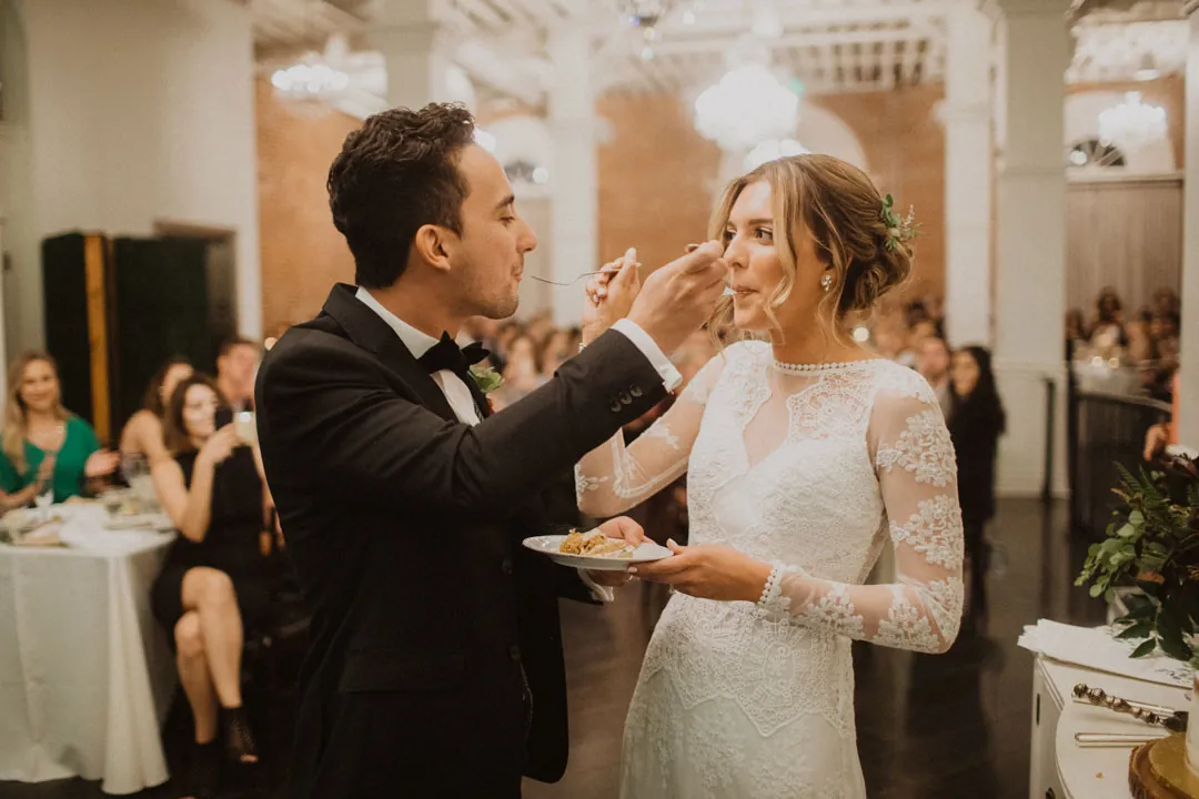 Groom feeding wedding cake to the bride