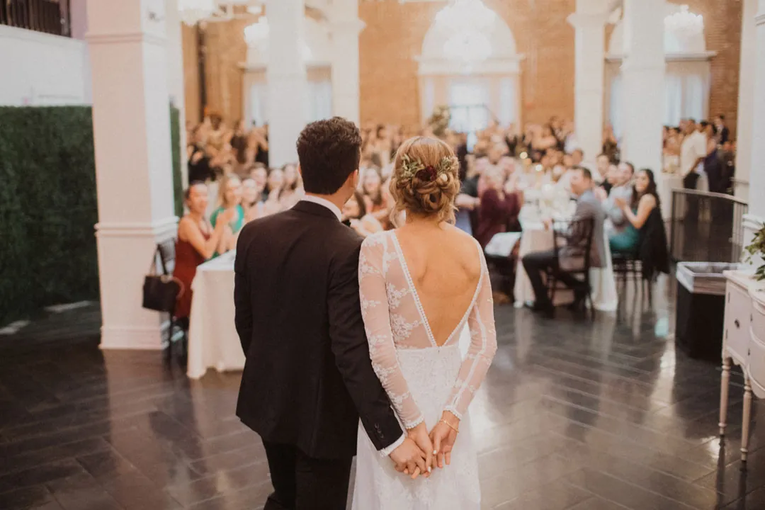 Couple dancing in a reception room surrounded by guests