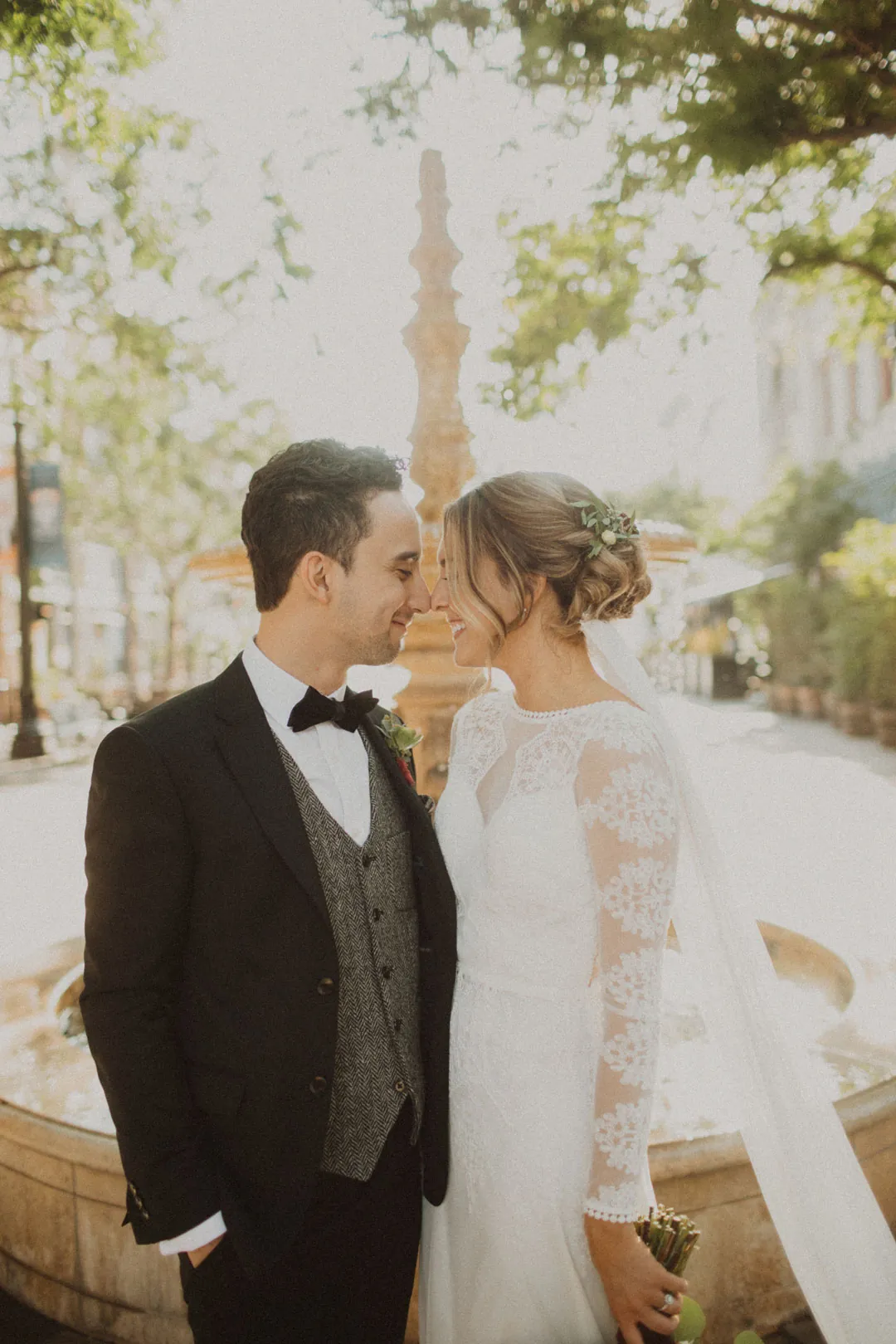 Couple embracing on a tree-lined city sidewalk
