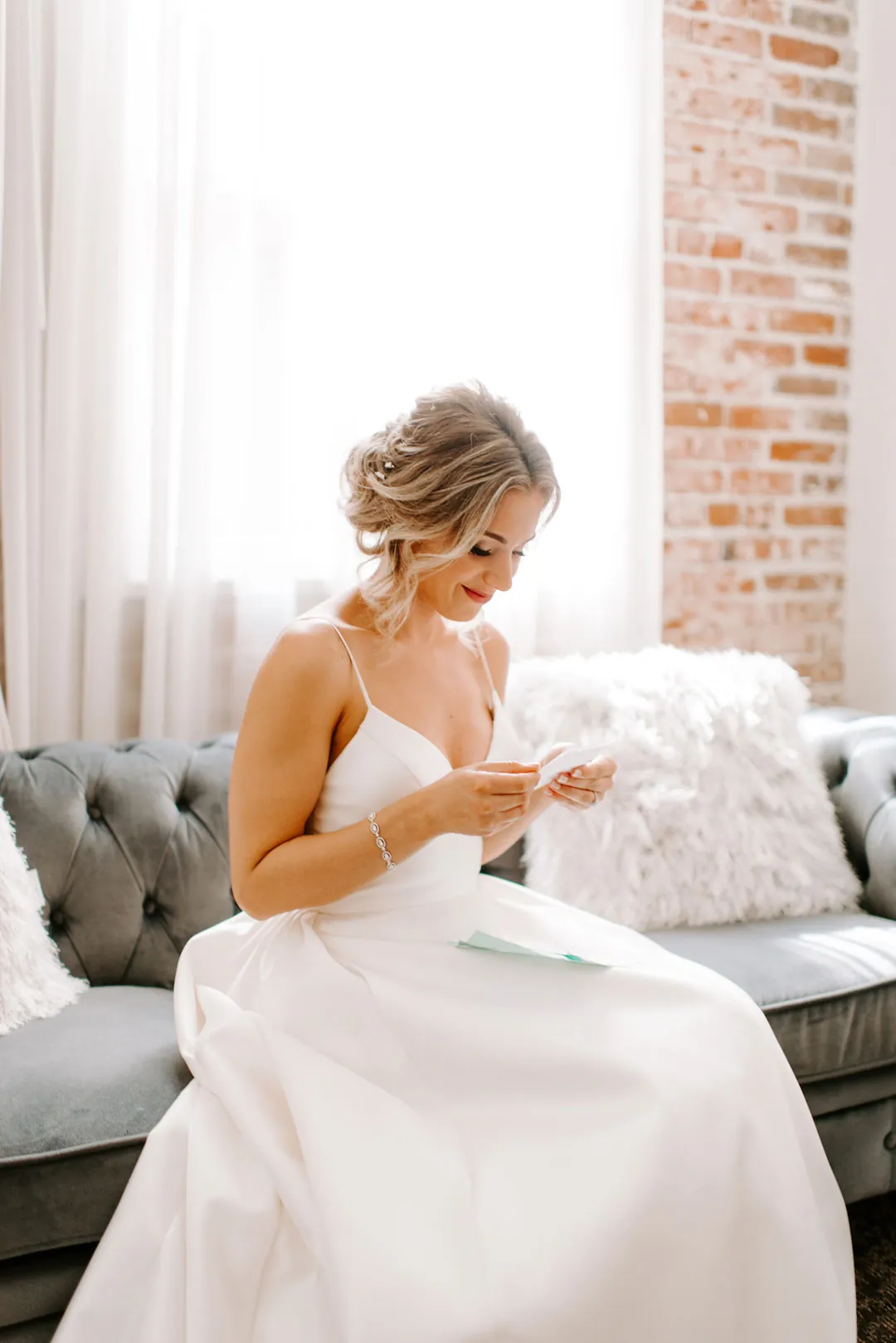 Bride seated on a sofa while getting ready