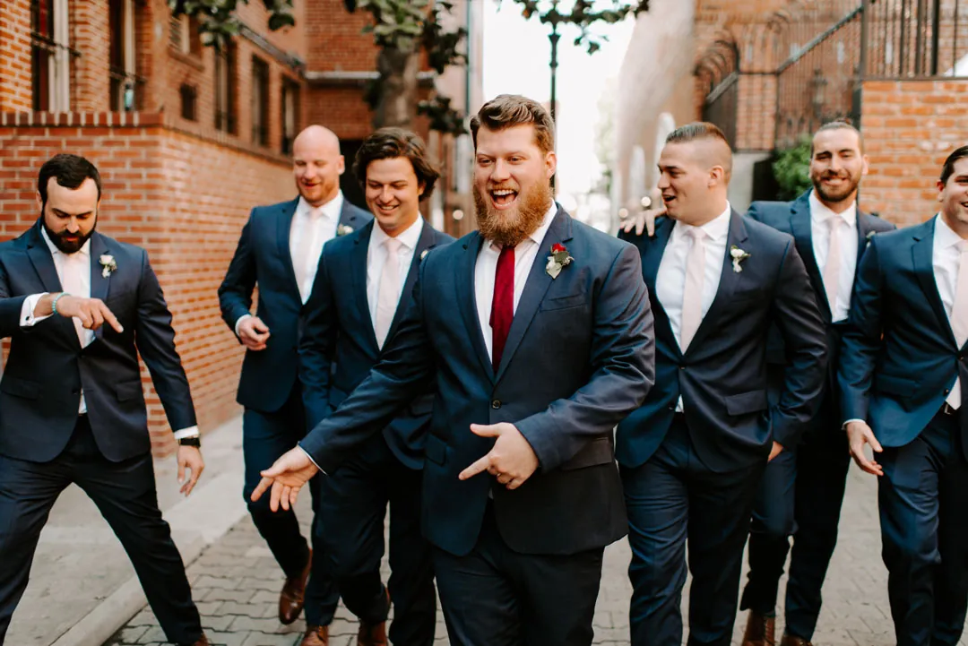 Groom and groomsmen walking in dark blue suits