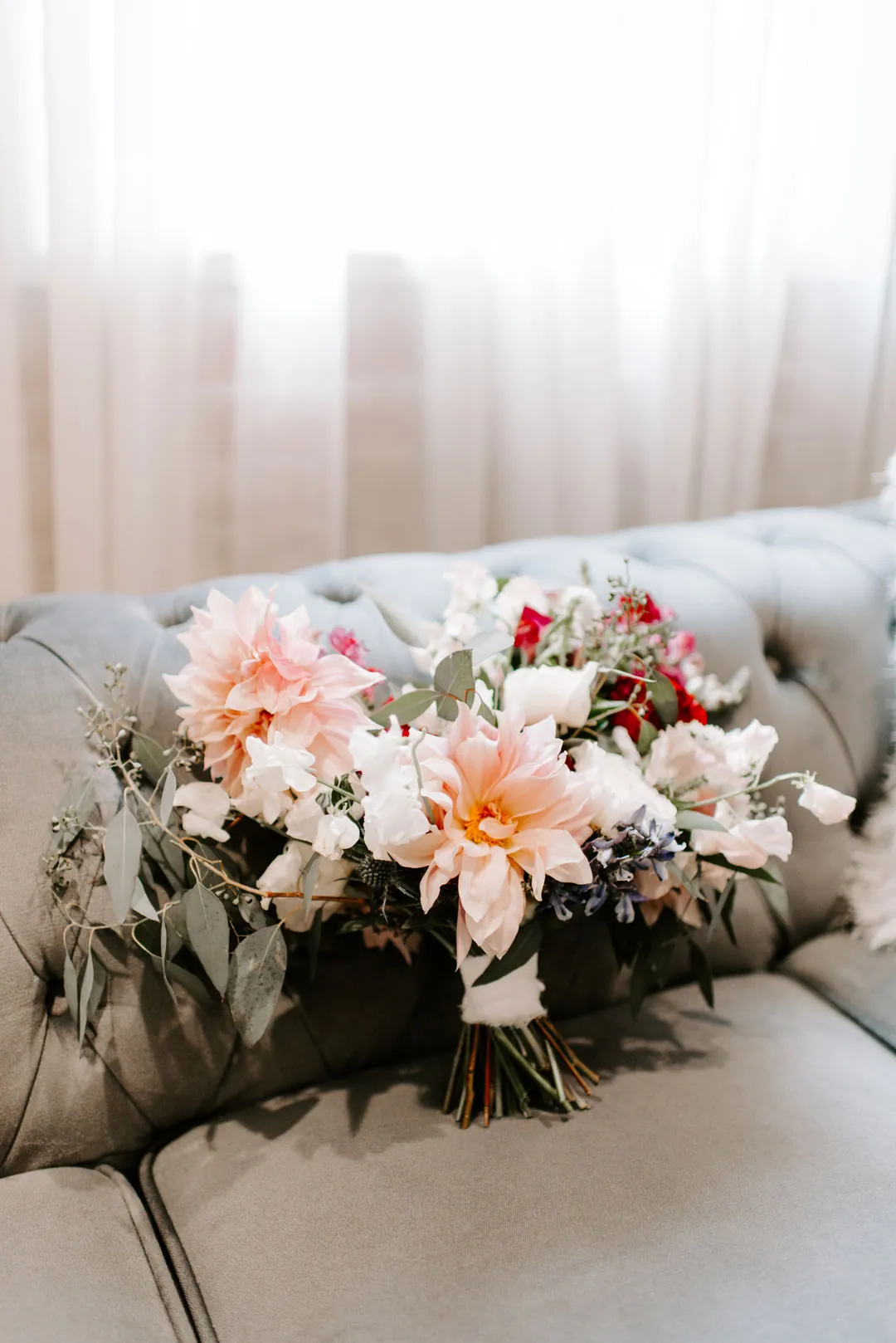 Wedding bouquet resting on a gray sofa