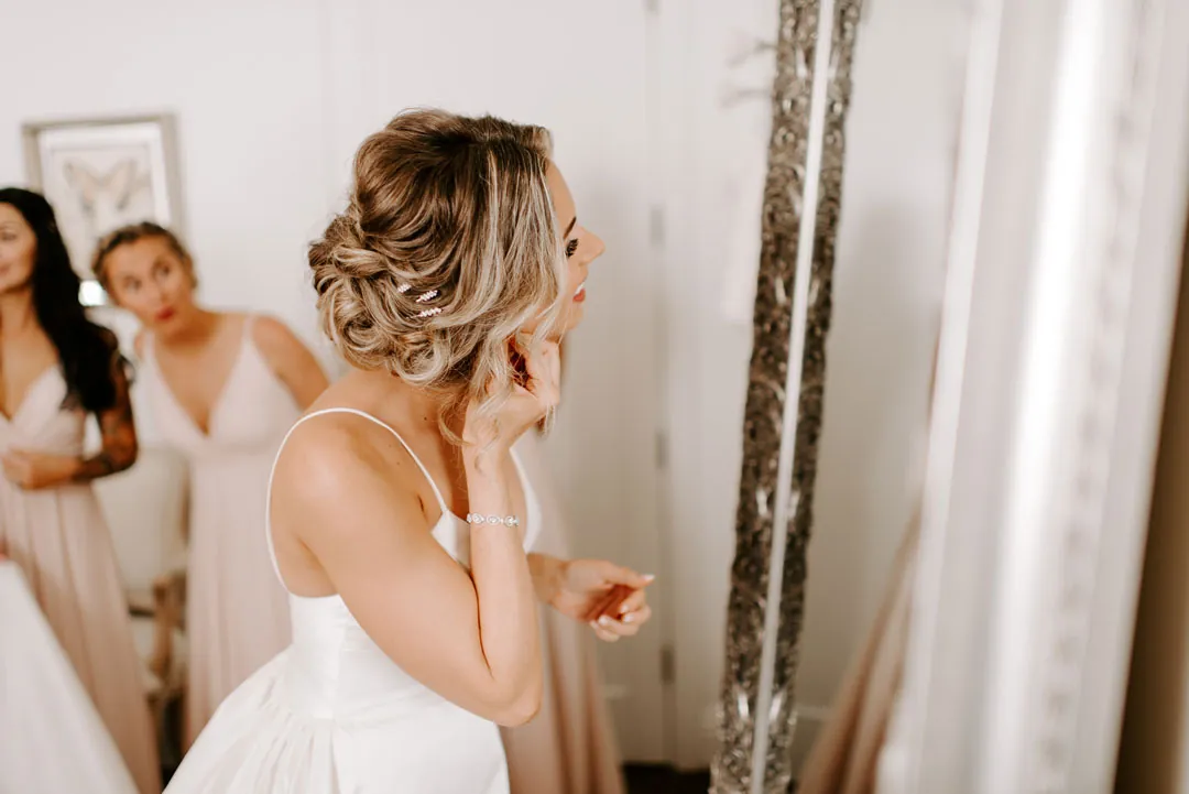 Bride standing beside a mirror