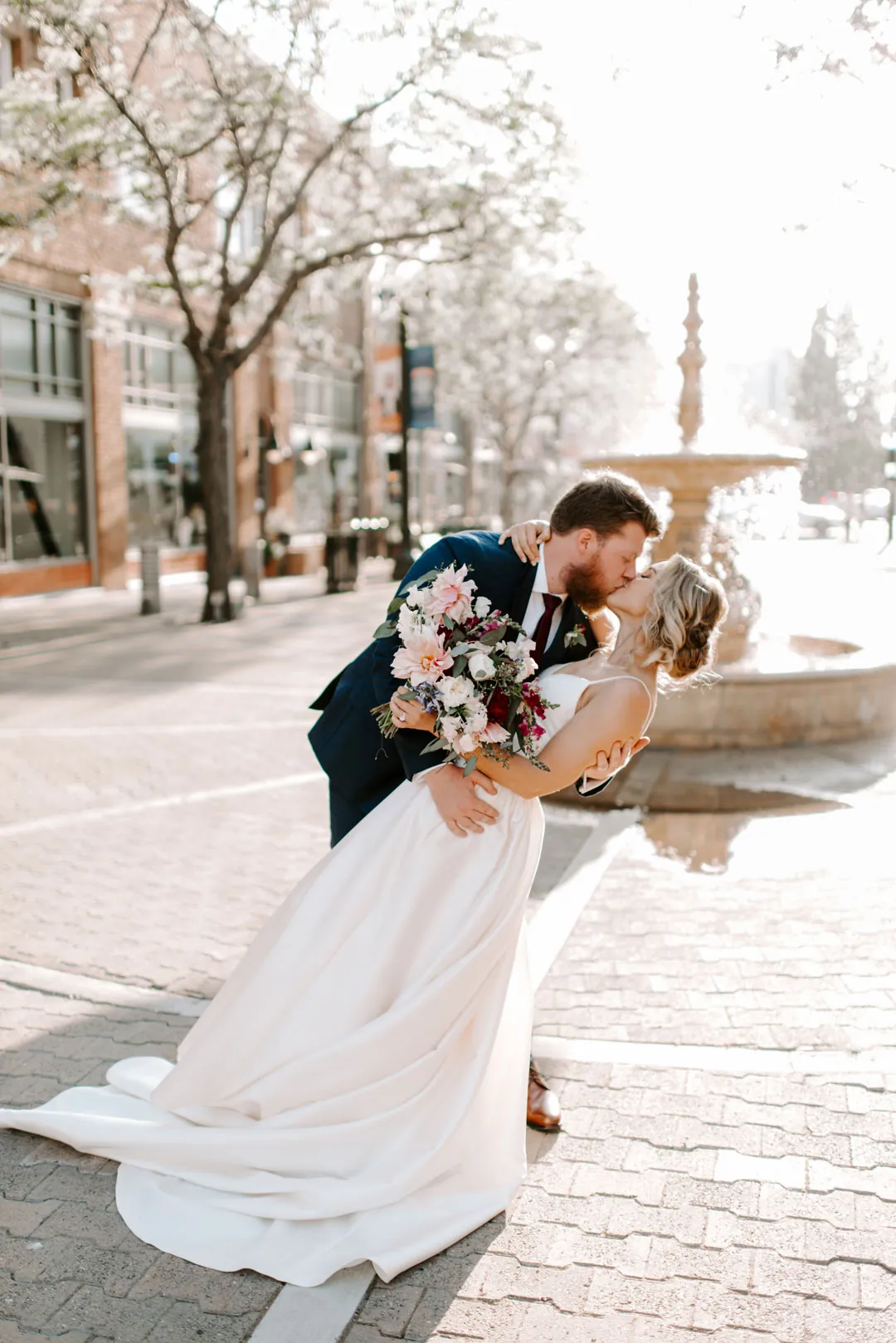 Bride and groom embracing on a sidewalk