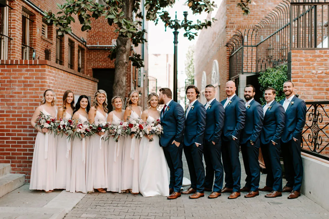 Wedding party posing together on a city sidewalk