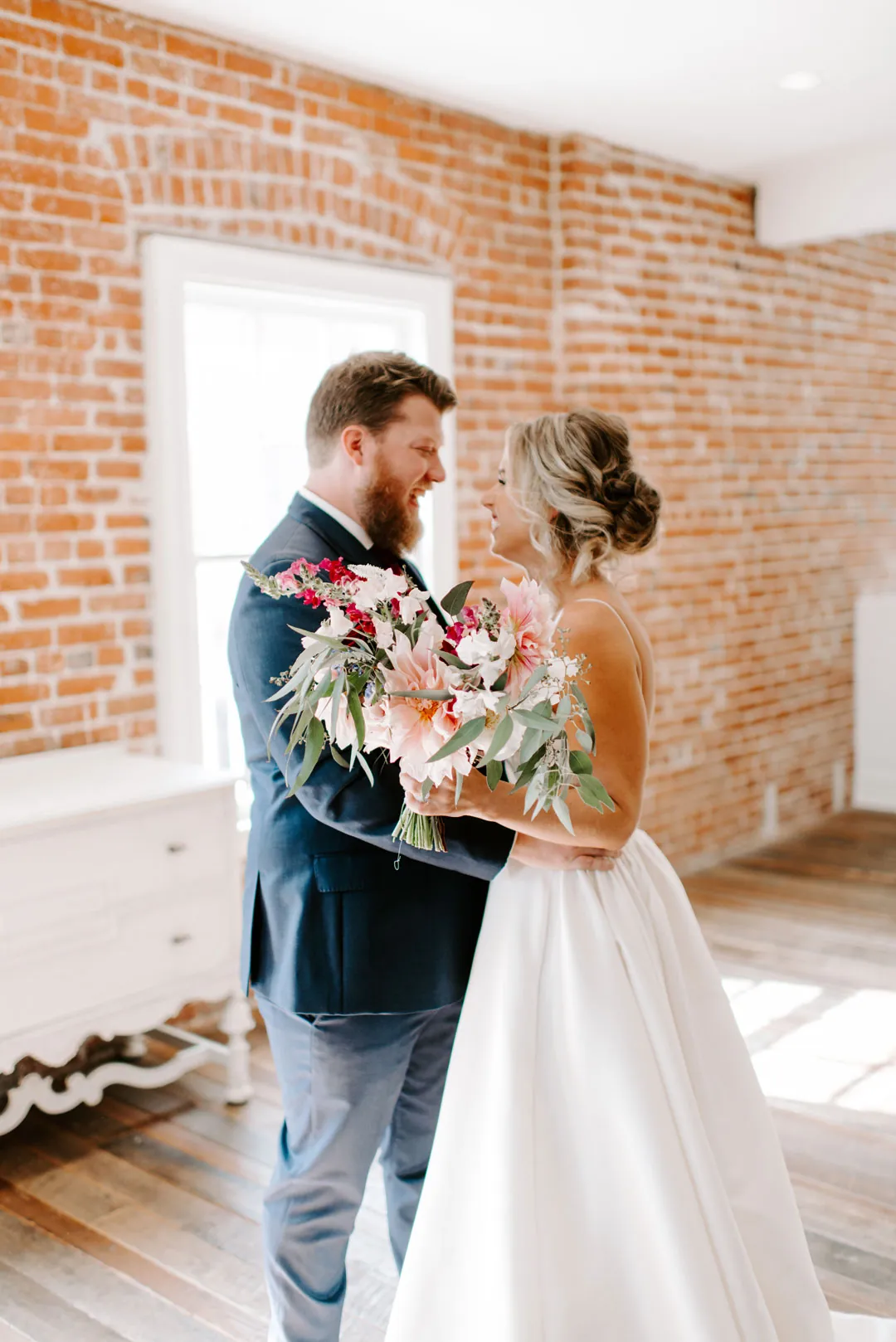 Bride and groom sharing their first look by a window