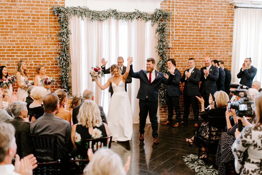 Newlyweds celebrating at the front of the ballroom