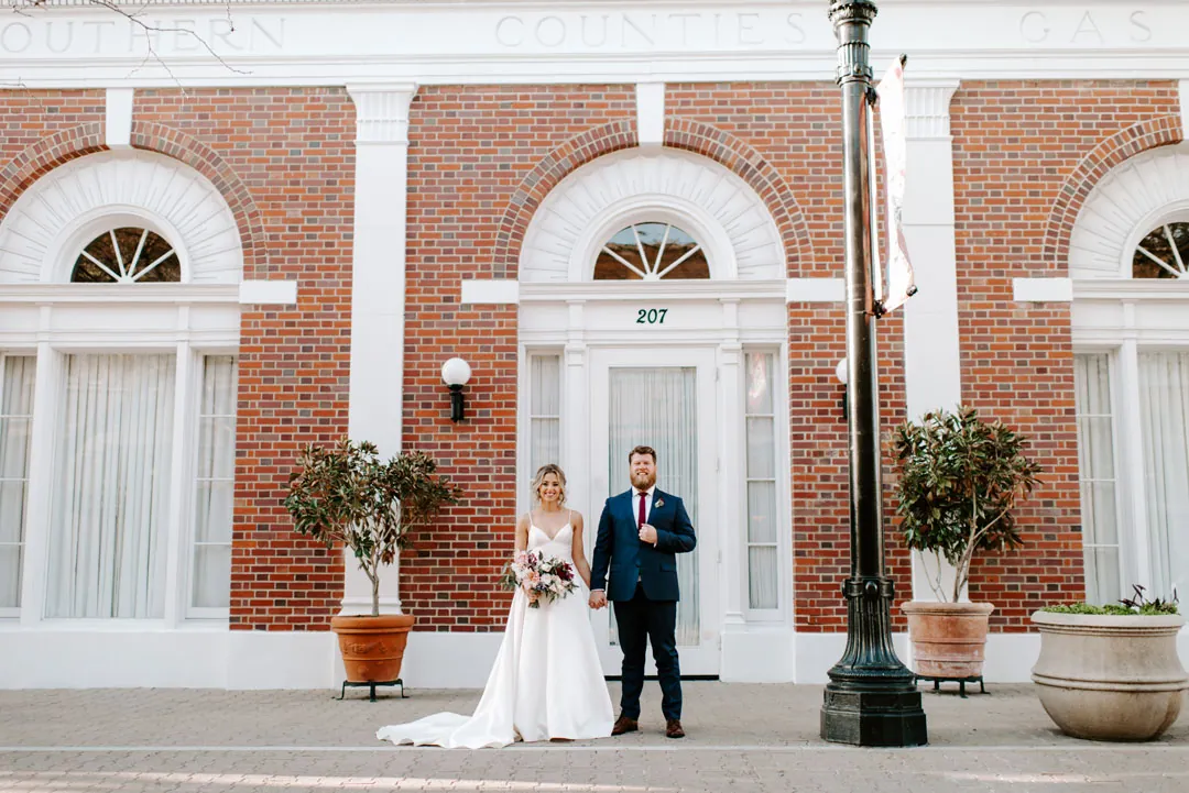 Bride and groom outside the brick venue entrance