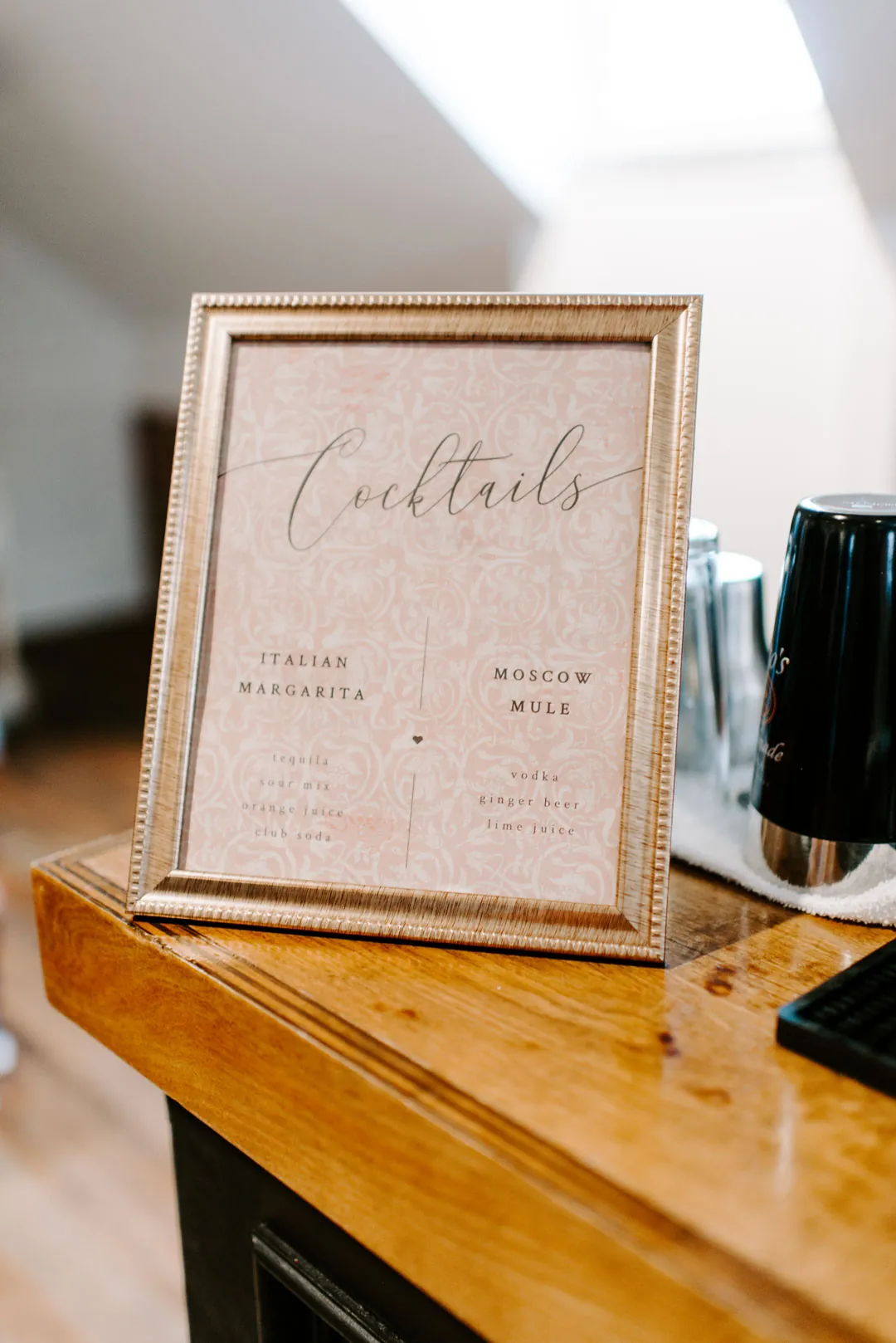 Framed cocktail menu on a wooden bar
