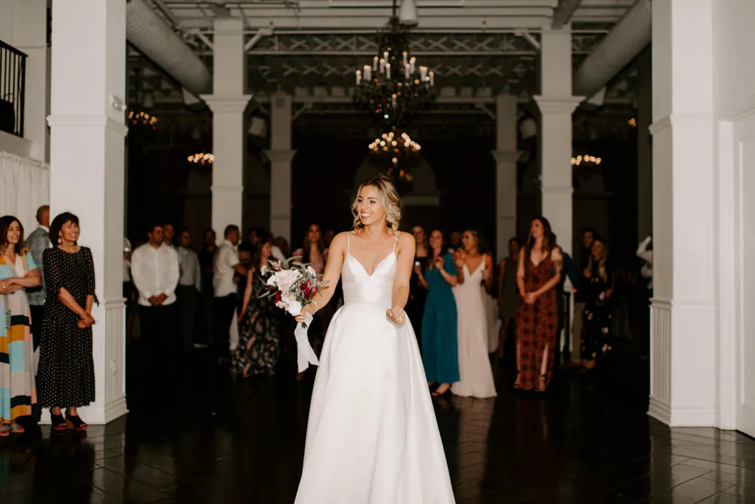 Bride standing before guests during the bouquet toss