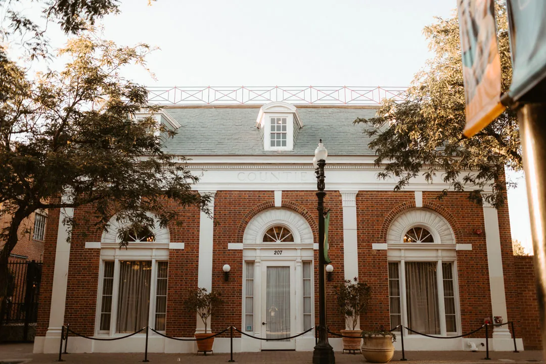 Estate on Second's brick facade beneath leafy trees