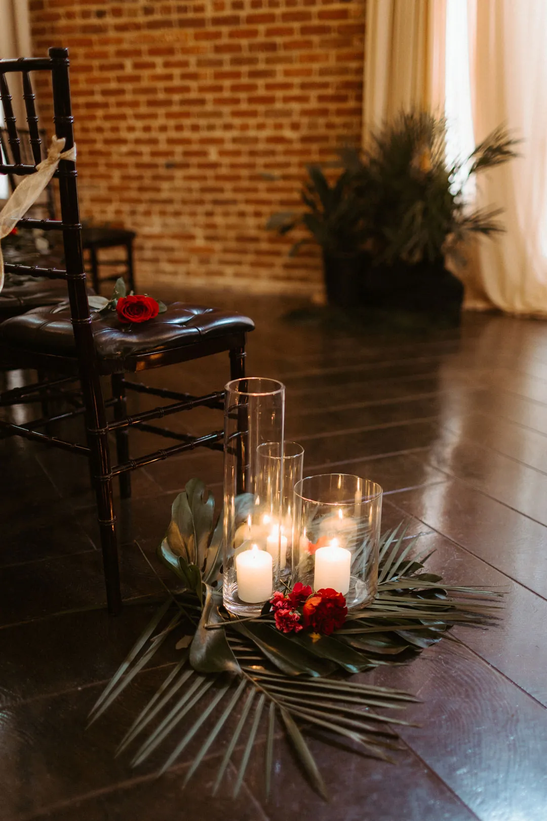 Candles and red flowers lining a ceremony aisle
