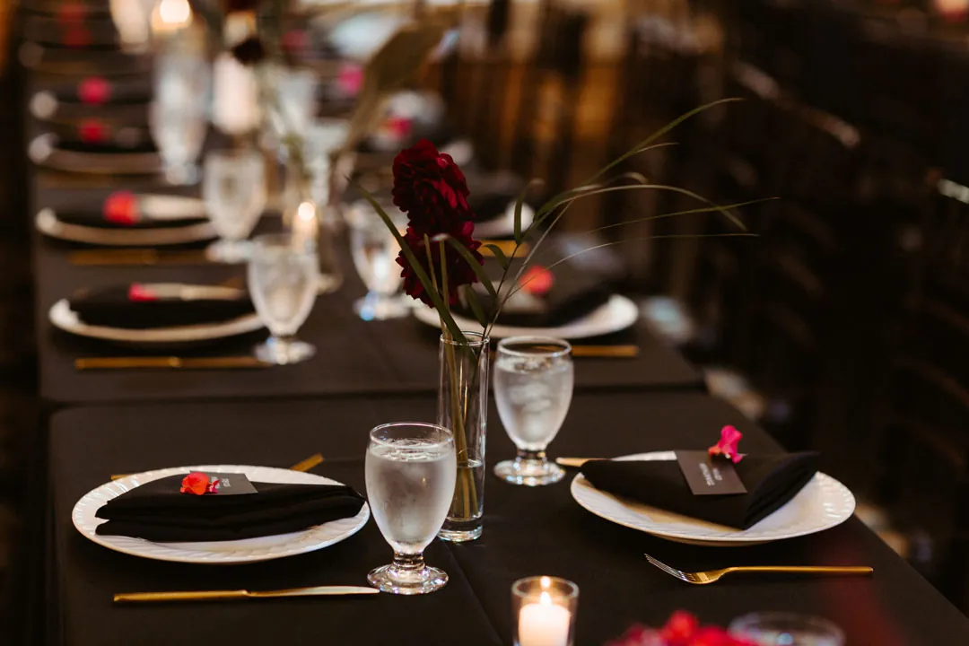 Dark place settings with red floral accents