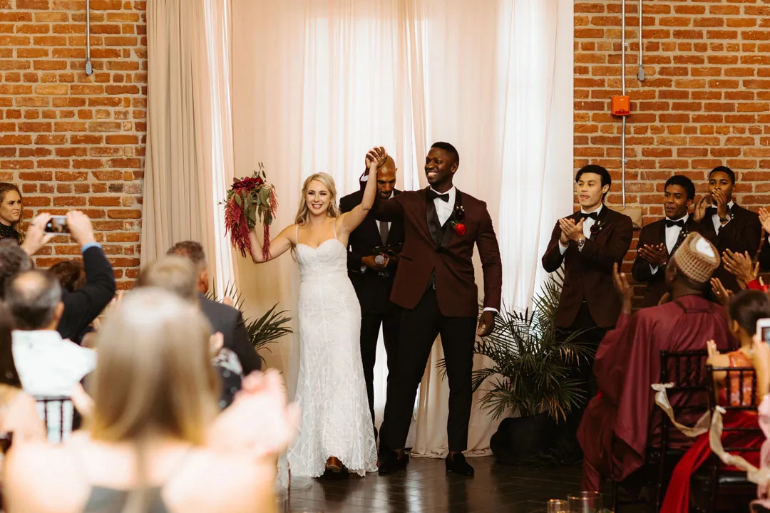 Newlyweds celebrating as they walk down the aisle