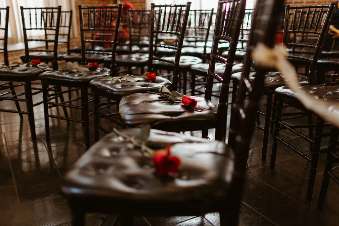 Ceremony chairs decorated with red flowers